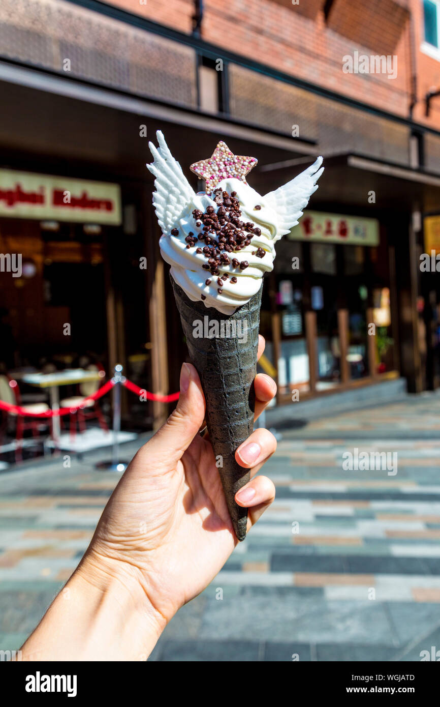 La crème glacée molle à la vanille décoré avec des ailes et étoile dans un cône noir à Taiyakiya, Chinatown, Londres, UK Banque D'Images