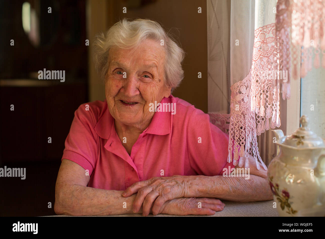 Portrait d'une vieille femme dans sa maison à la cuisine. Banque D'Images
