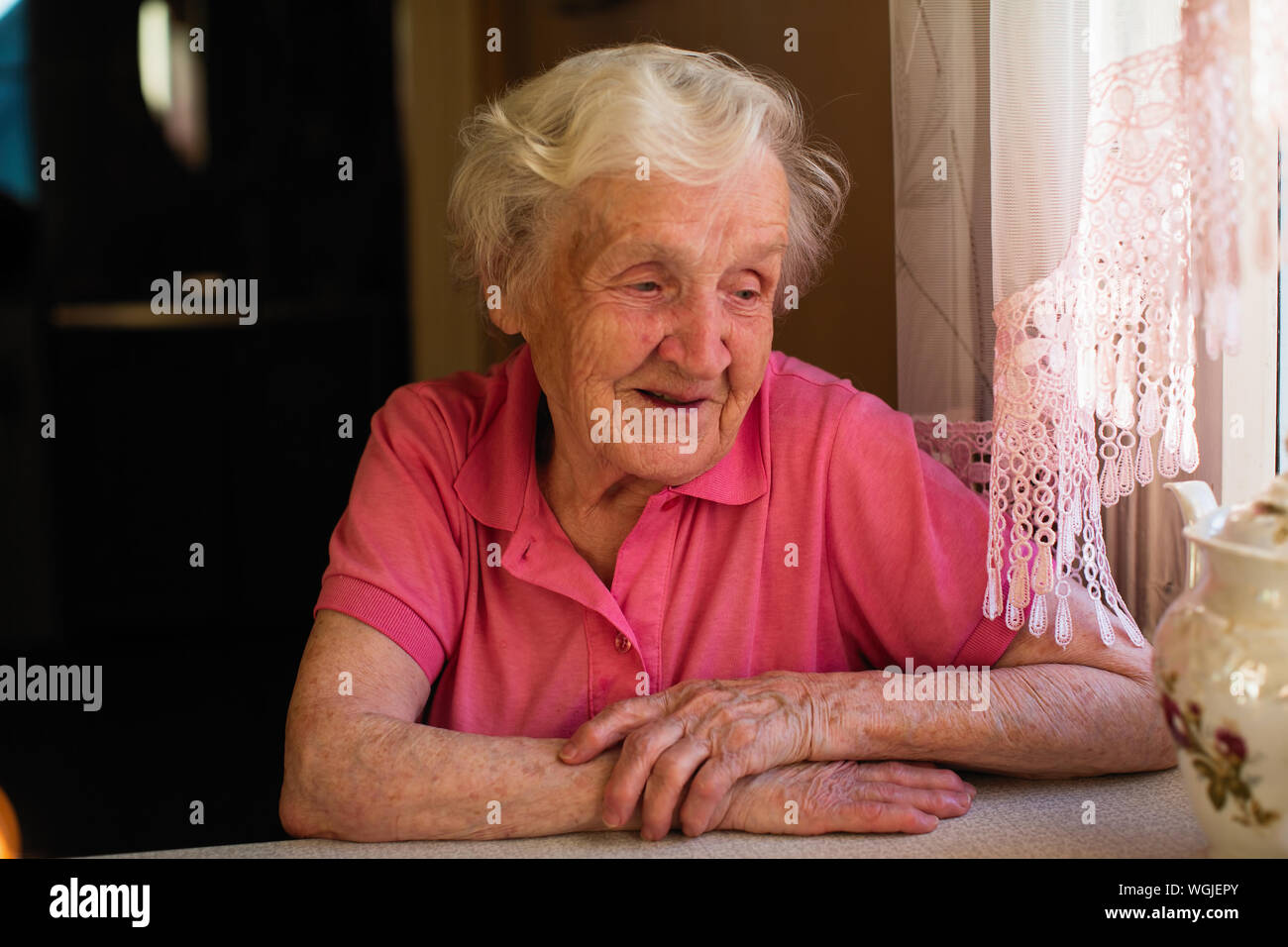 Femme âgée assise à la table. Banque D'Images
