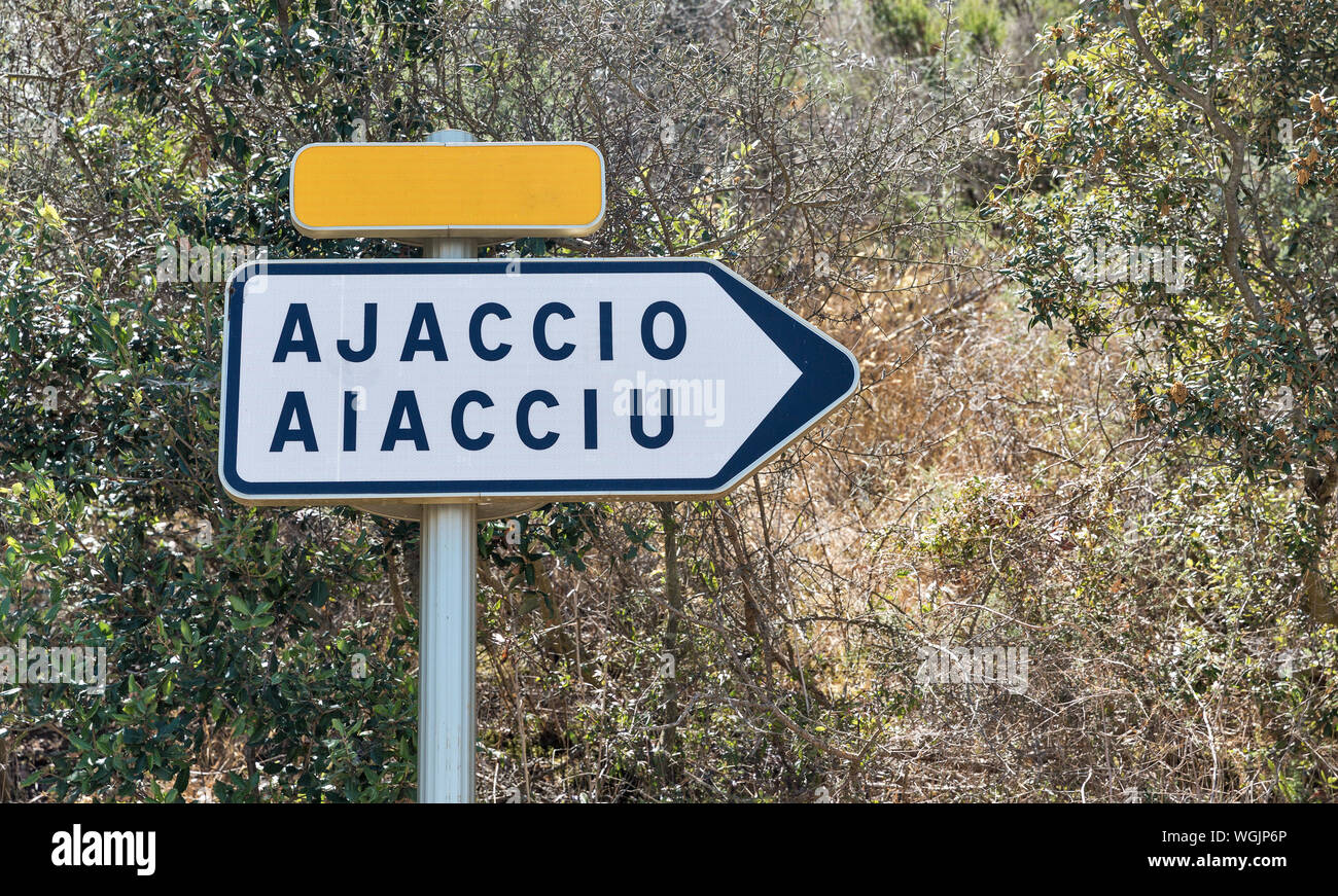 Ajaccio panneau routier. Flèche blanche avec le nom de la ville de destination, l'espace de copie jaune plaque. L'île de Corse, France. Banque D'Images