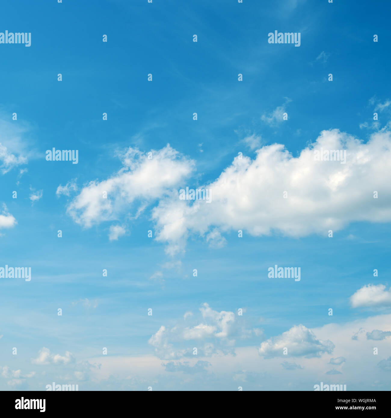 Fond céleste - blanc duveteux nuages dans le ciel bleu vif. Banque D'Images