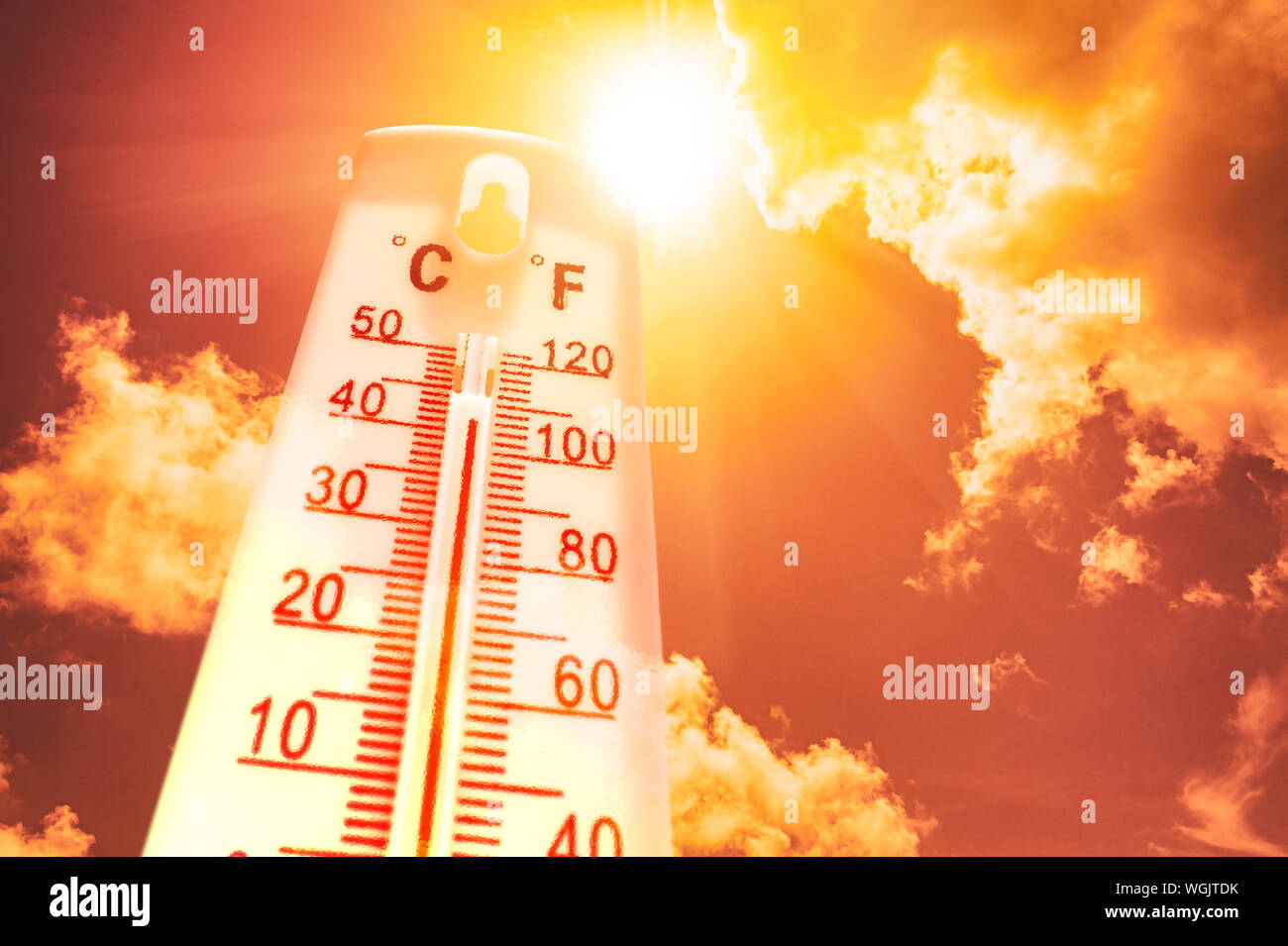 Thermomètre en face d'un ciel avec soleil et nuages Banque D'Images