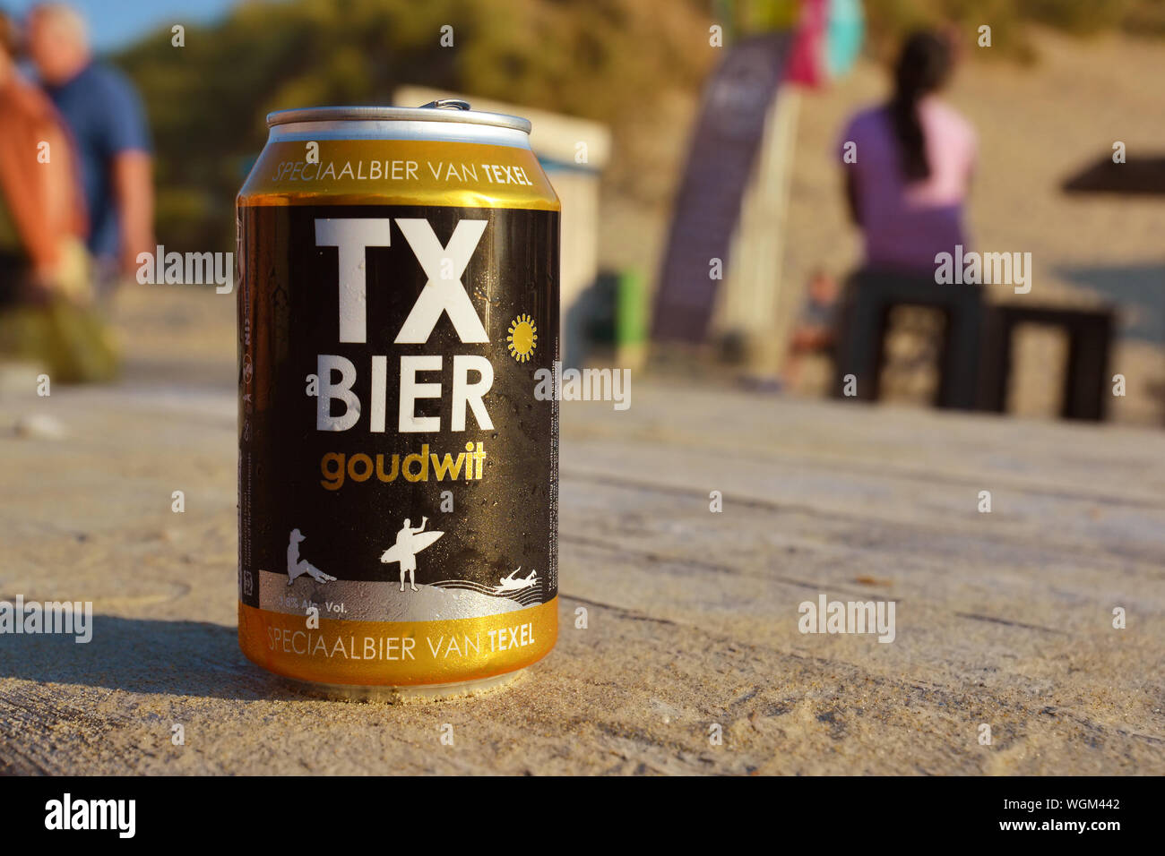 Une canette de bière appelée "TX" Goudwit Bier à partir de la brasserie locale sur l'île Texel hollandais debout sur une table en bois couverte de sable sur plage Banque D'Images