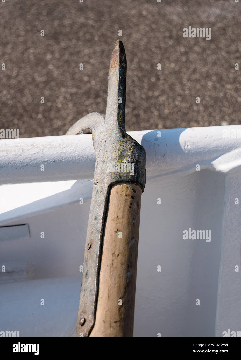 Close-up of old, boothook utilisé fait de métal et de bois debout à bateau blanc point de mouillage à balustrade à jour. Banque D'Images