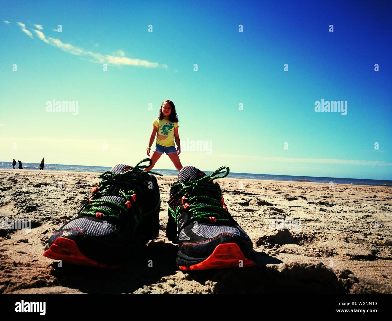 Illusion optique d'Girl Chaussures énormes sur la plage contre le ciel bleu  Photo Stock - Alamy
