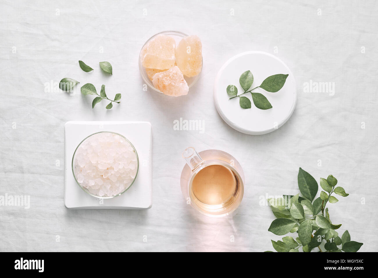 L'aromathérapie. Petites bouteilles en verre avec des huiles cosmétiques. Sels de bain. Des feuilles fraîches. Pour les objets procédures spa sur fond blanc, d'huile de laurier. Banque D'Images