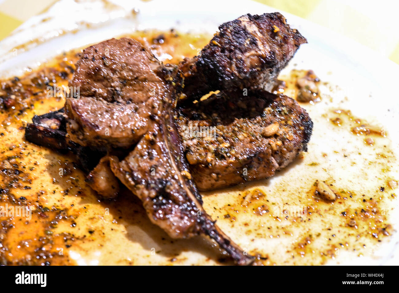 Bien fait faux-filet de boeuf gras en plaque blanche. La bavette à l'adjudication La cuisine c'est bien fait et est brillant de la jus séchant sur la plaque blanche. Banque D'Images