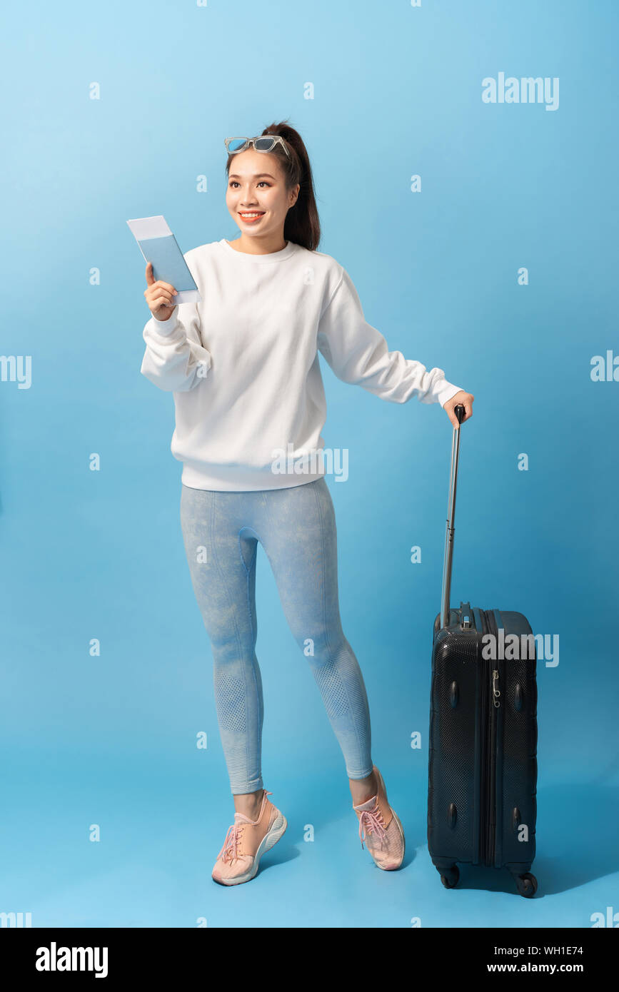 Tourisme, vacances d'été et vacances - Happy woman in casual vêtements avec un sac de voyage et billet d'air sur fond bleu Banque D'Images