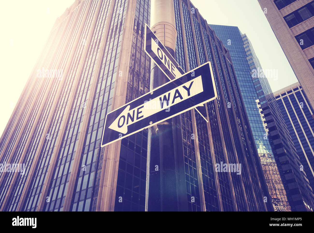 Les plaques de rue à sens unique contre le soleil dans la ville de New York, harmonisation des couleurs appliquées, USA. Banque D'Images