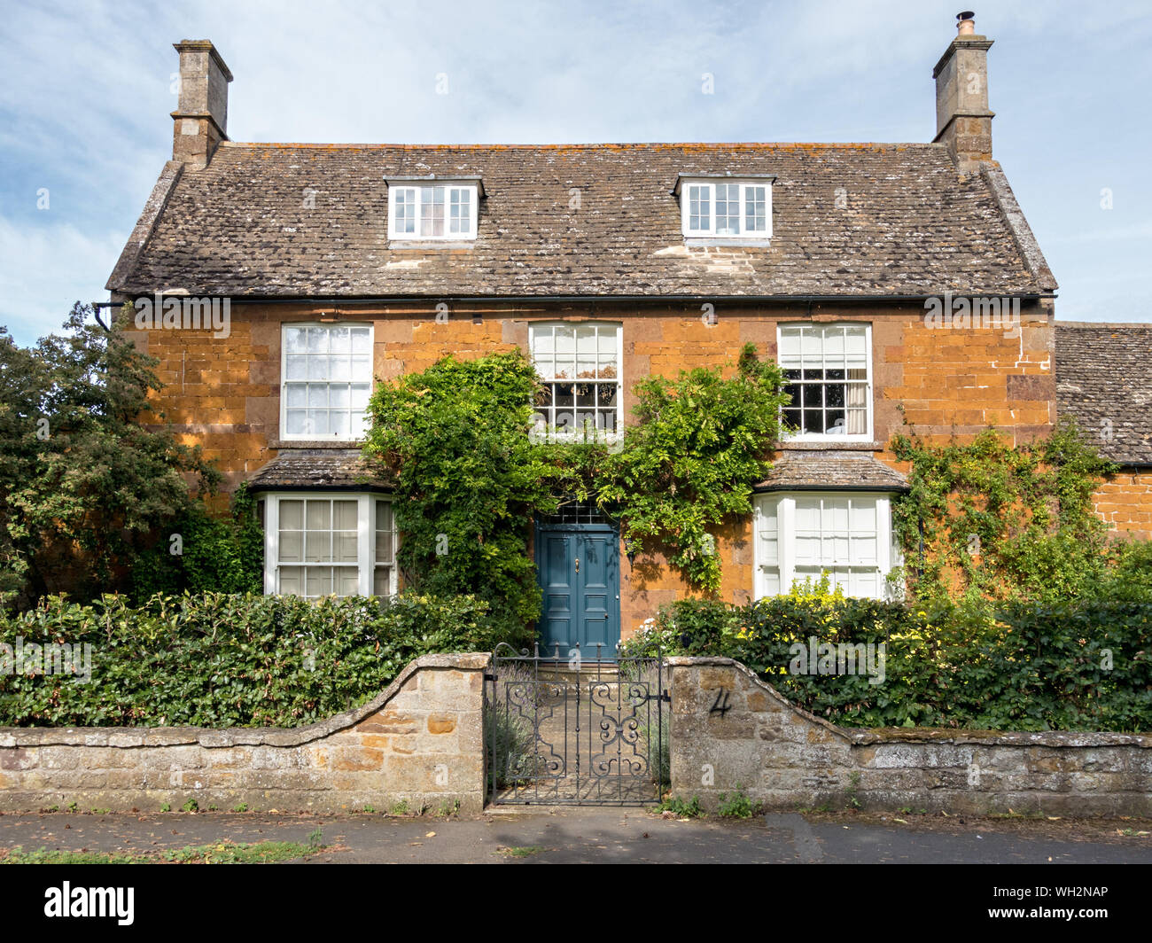 La maison 'bell'. Un joli , vieux (C18), maison ironstone Collyweston avec toiture en ardoise et le châssis et fenêtres en baie, Lyddington, Rutland, England, UK Banque D'Images