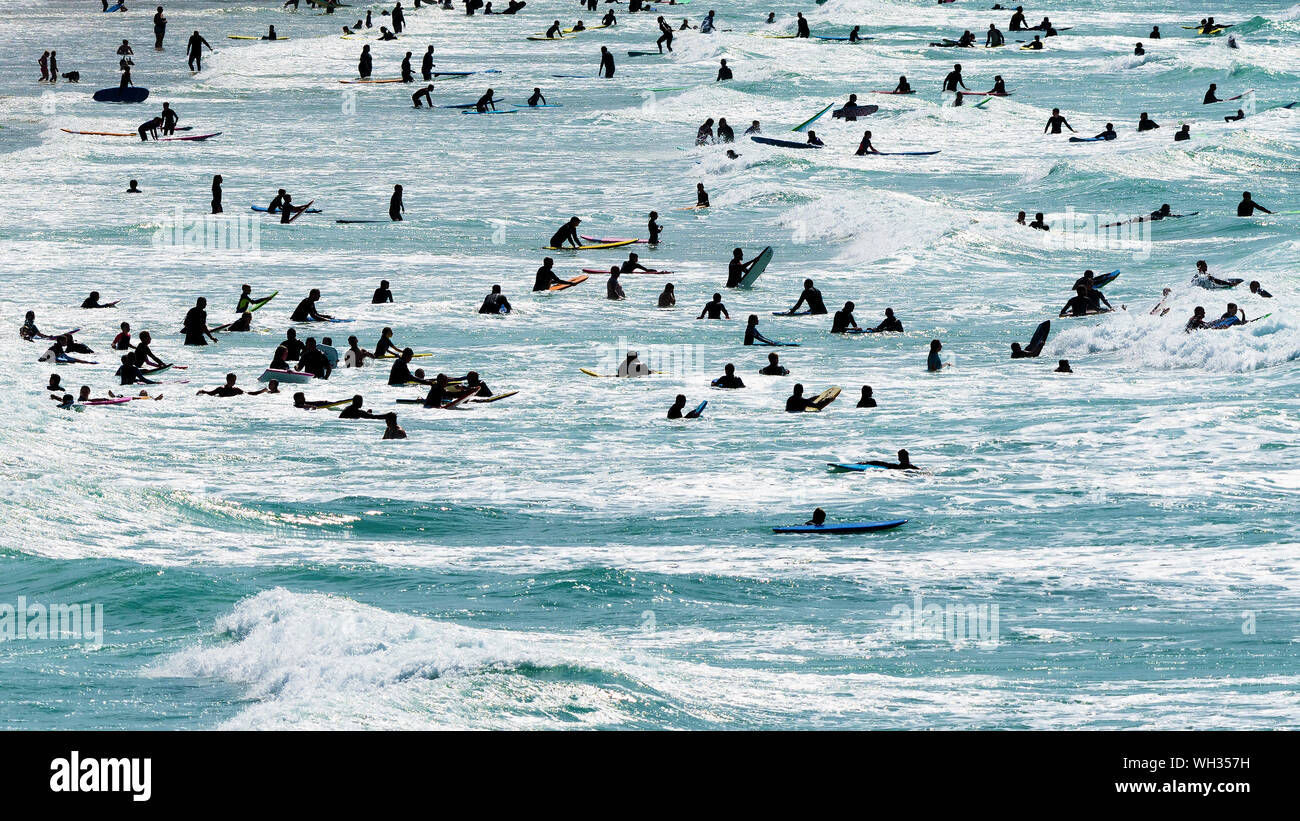 Les vacanciers s'amuser dans la mer vu en silhouette à Newquay dans Fistral à Cornwall. ; Banque D'Images