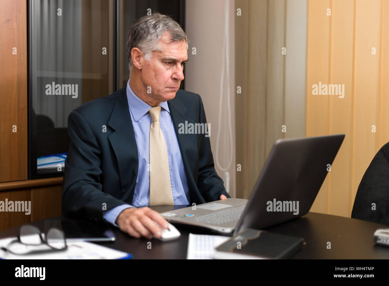 De graves senior businessman reading business documents dans Office. Gestionnaire principal de l'examen pour bien d'entreprise pour contrat. Portrait de la sen Banque D'Images