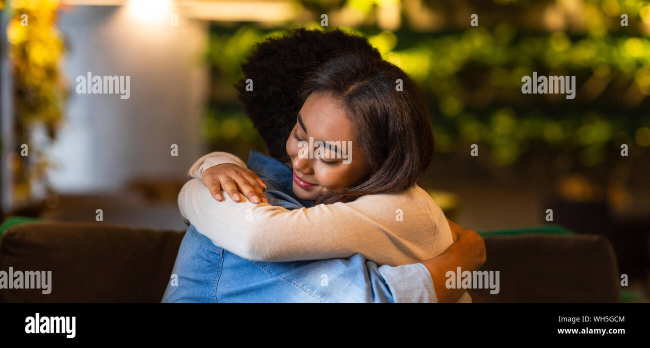 Teen girl hugging son petit ami avec les yeux fermé Banque D'Images