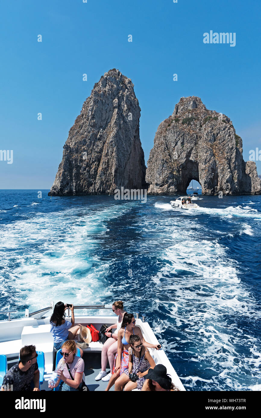 Les touristes sur un bateau pour les faraglioni hors de l'île de Capri, Italie. Banque D'Images