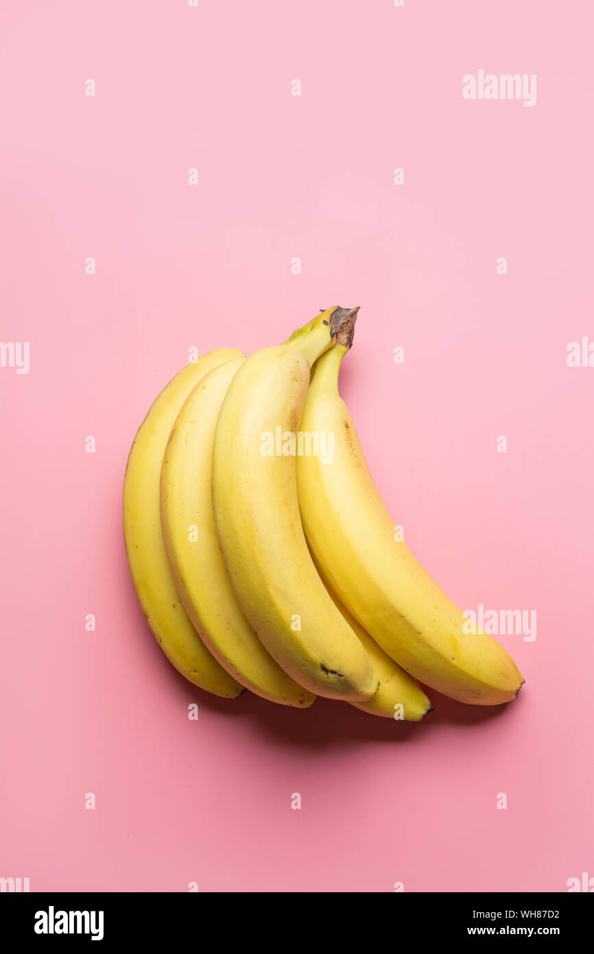 Bande de bananes jaunes mûrs sur fond rose. Vue de dessus. Food concept minimal. Banque D'Images