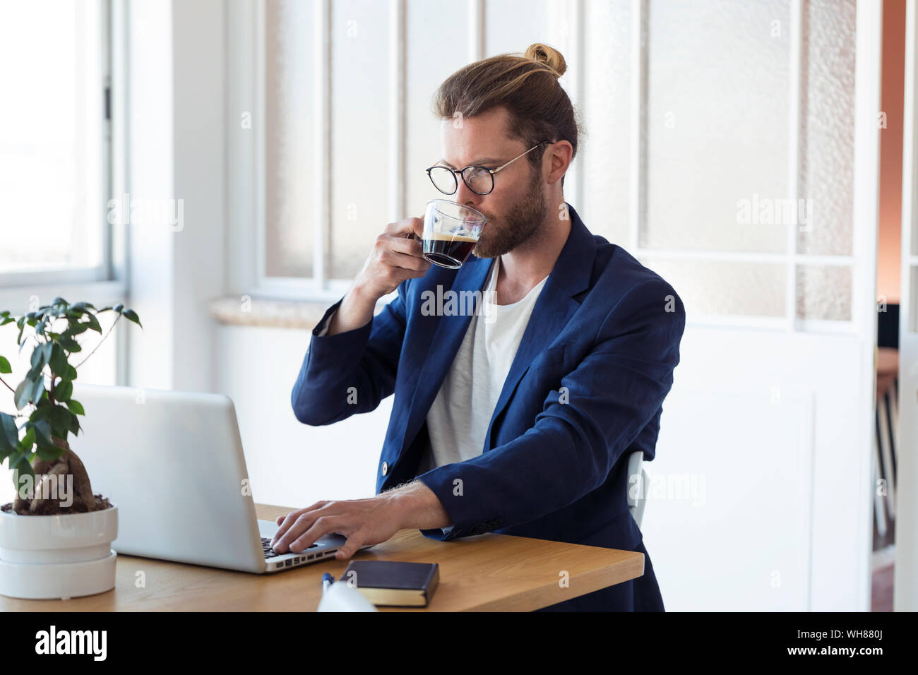 Businessman with laptop et tasse de café à la table Banque D'Images