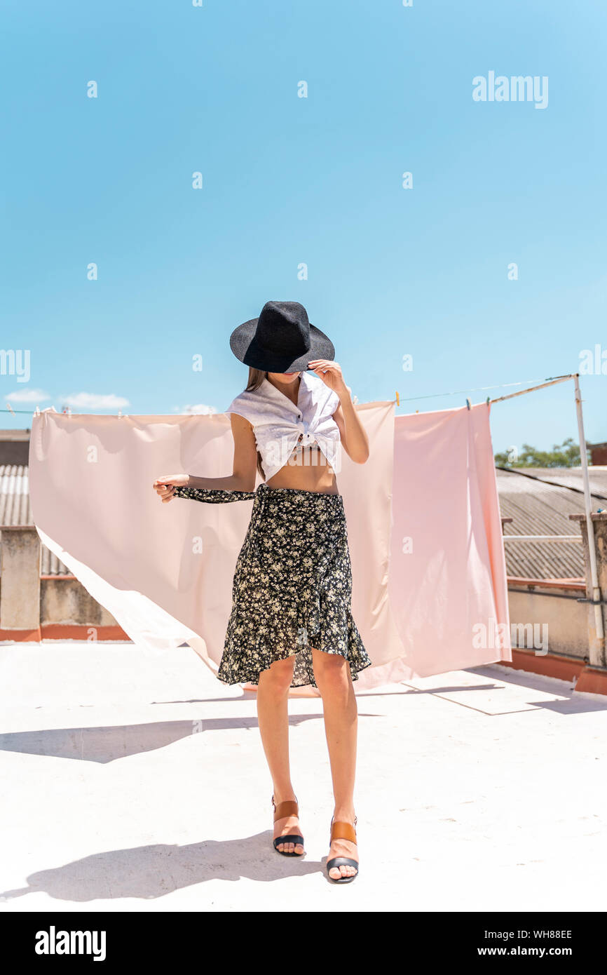 Fashionable young woman wearing hat, wrap-around de blouses et de jupes avec floral design Banque D'Images