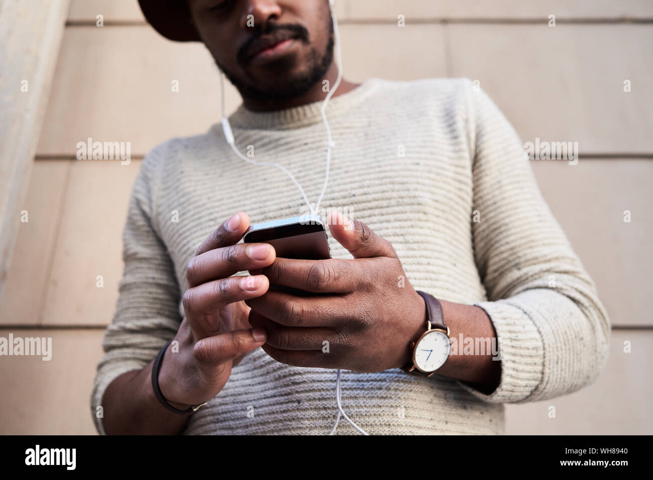 Mid adult man using smartphone et écouter de la musique Banque D'Images