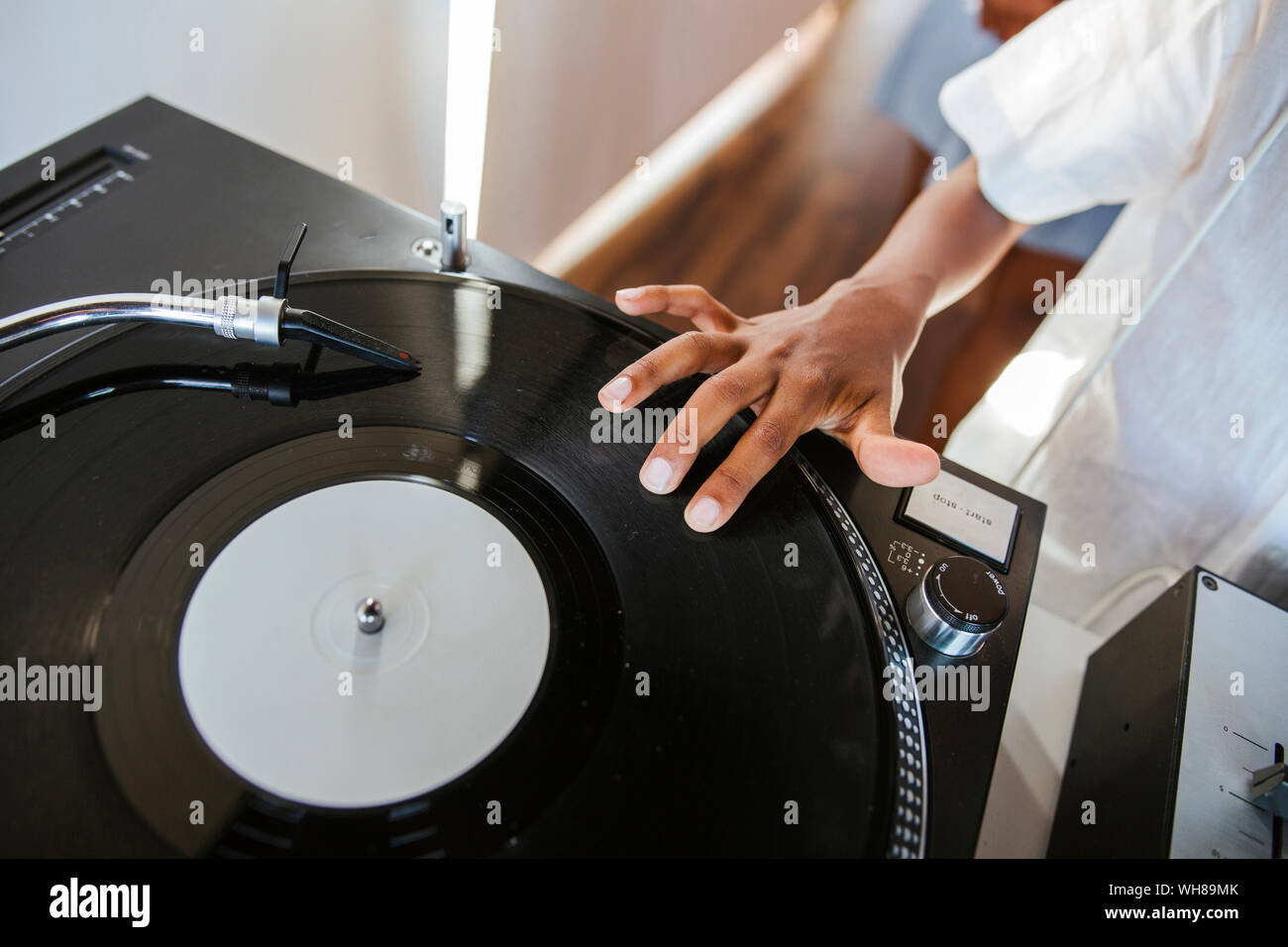 Main d'un jeune dj sur disque vinyle sur platine Banque D'Images