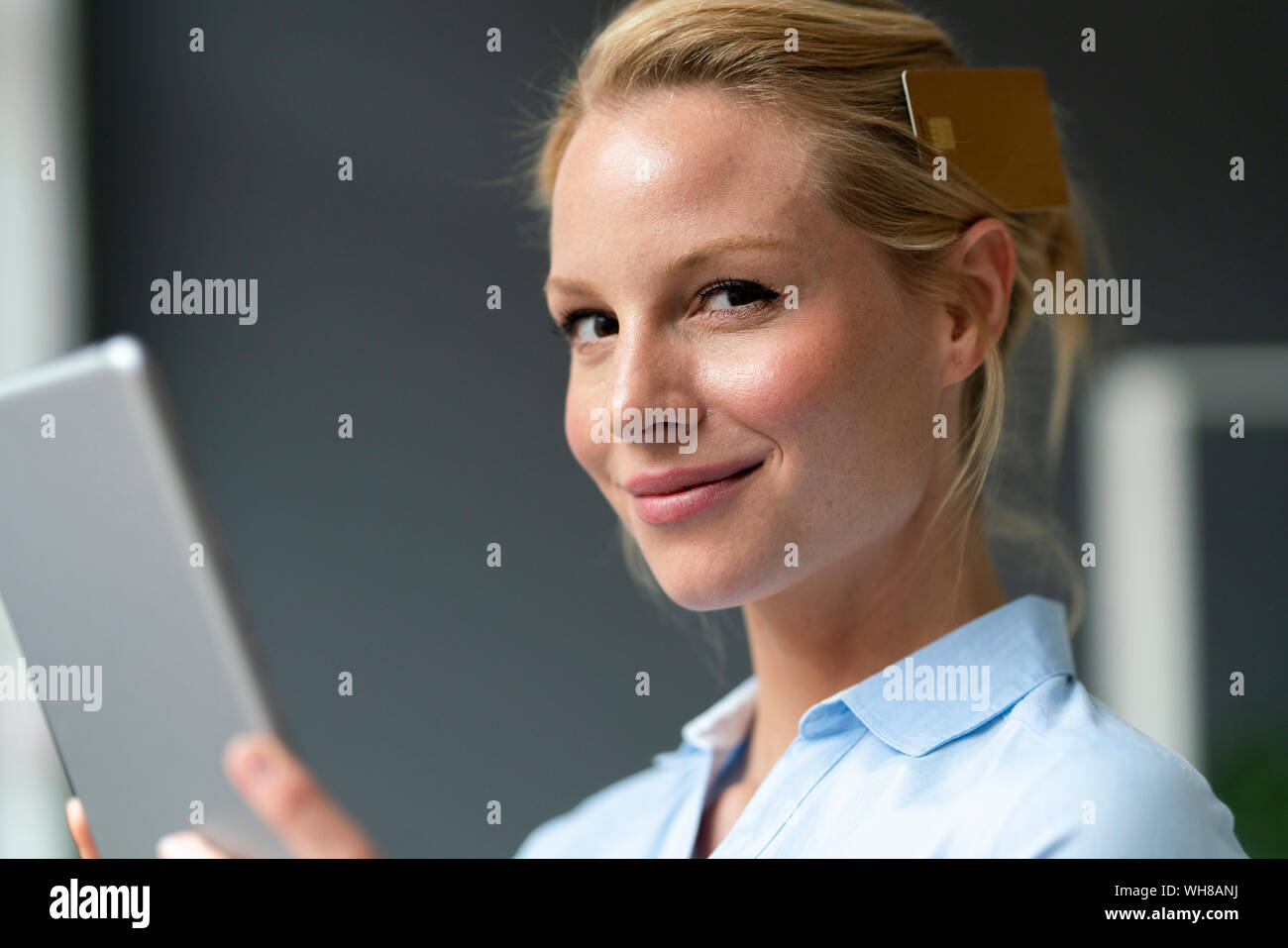 Portrait of smiling young woman with tablet et une carte de crédit Banque D'Images