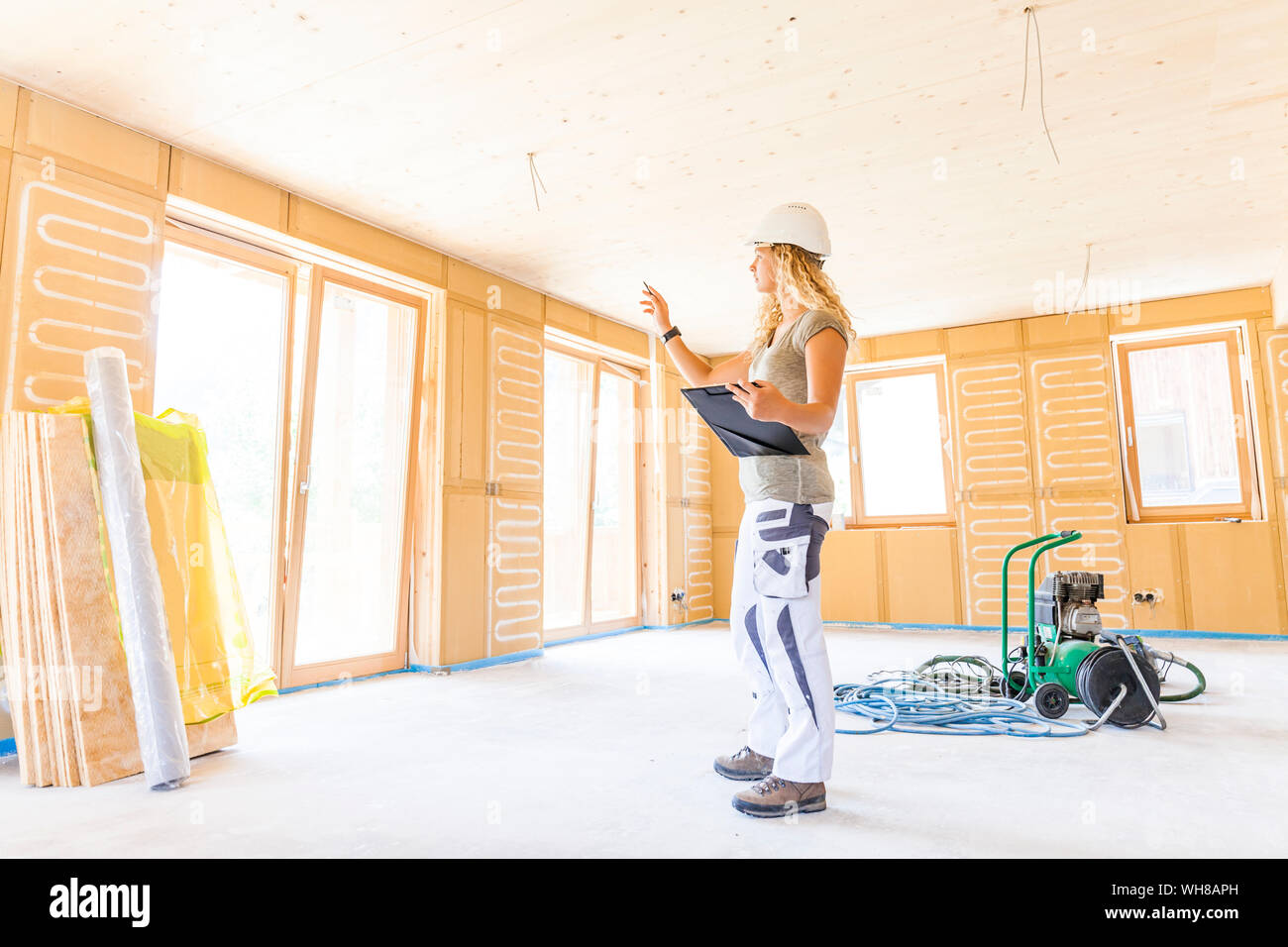 Jeune femme contrôle de la construction d'une nouvelle maison en bois Banque D'Images