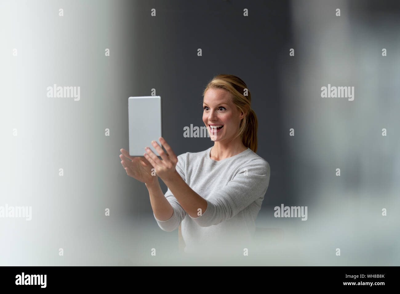 Happy young woman holding tablet Banque D'Images