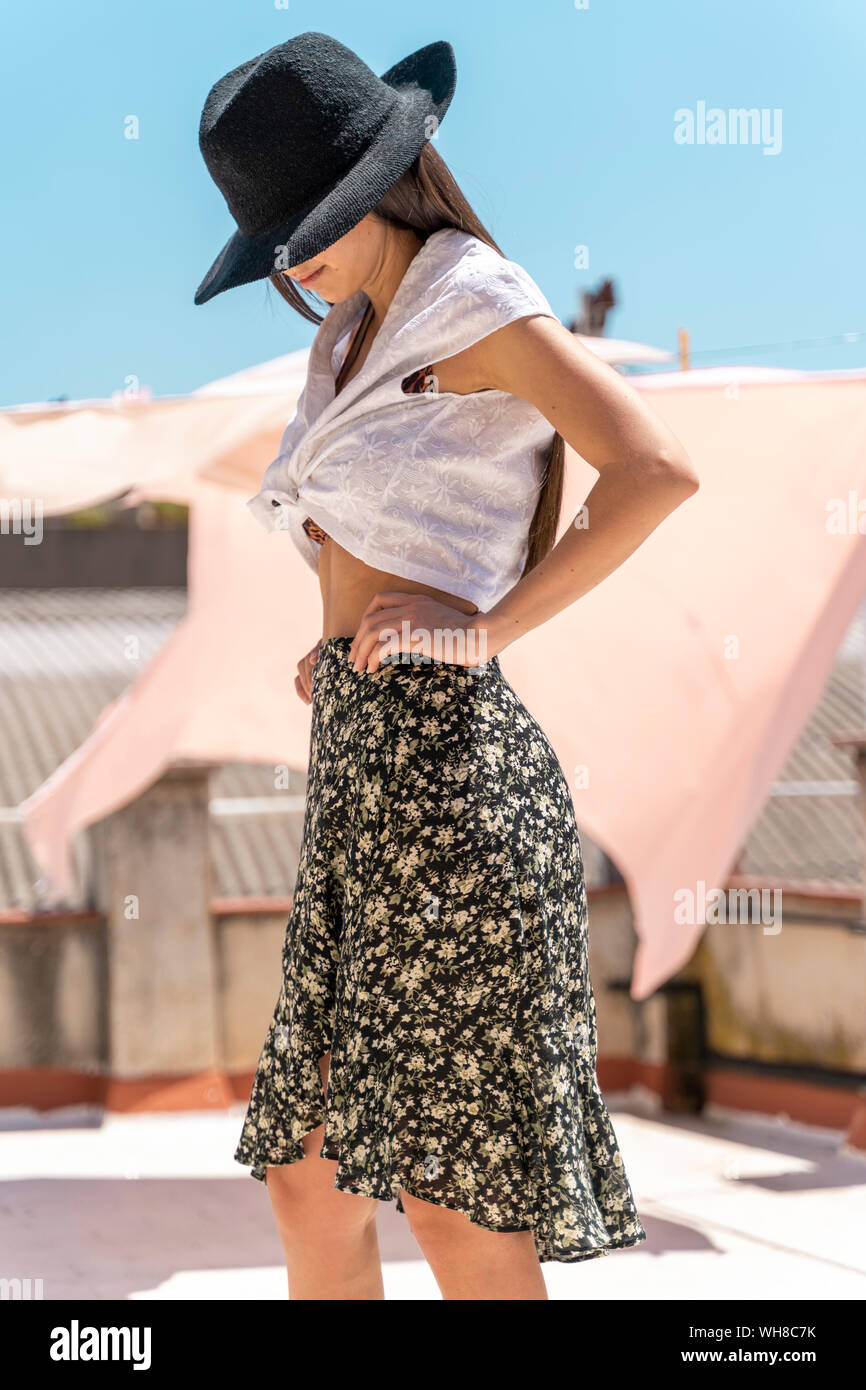 Fashionable young woman wearing hat, wrap-around de blouses et de jupes avec floral design Banque D'Images