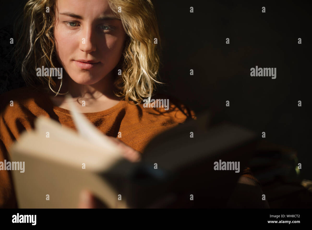 Young blonde woman reading a book Banque D'Images