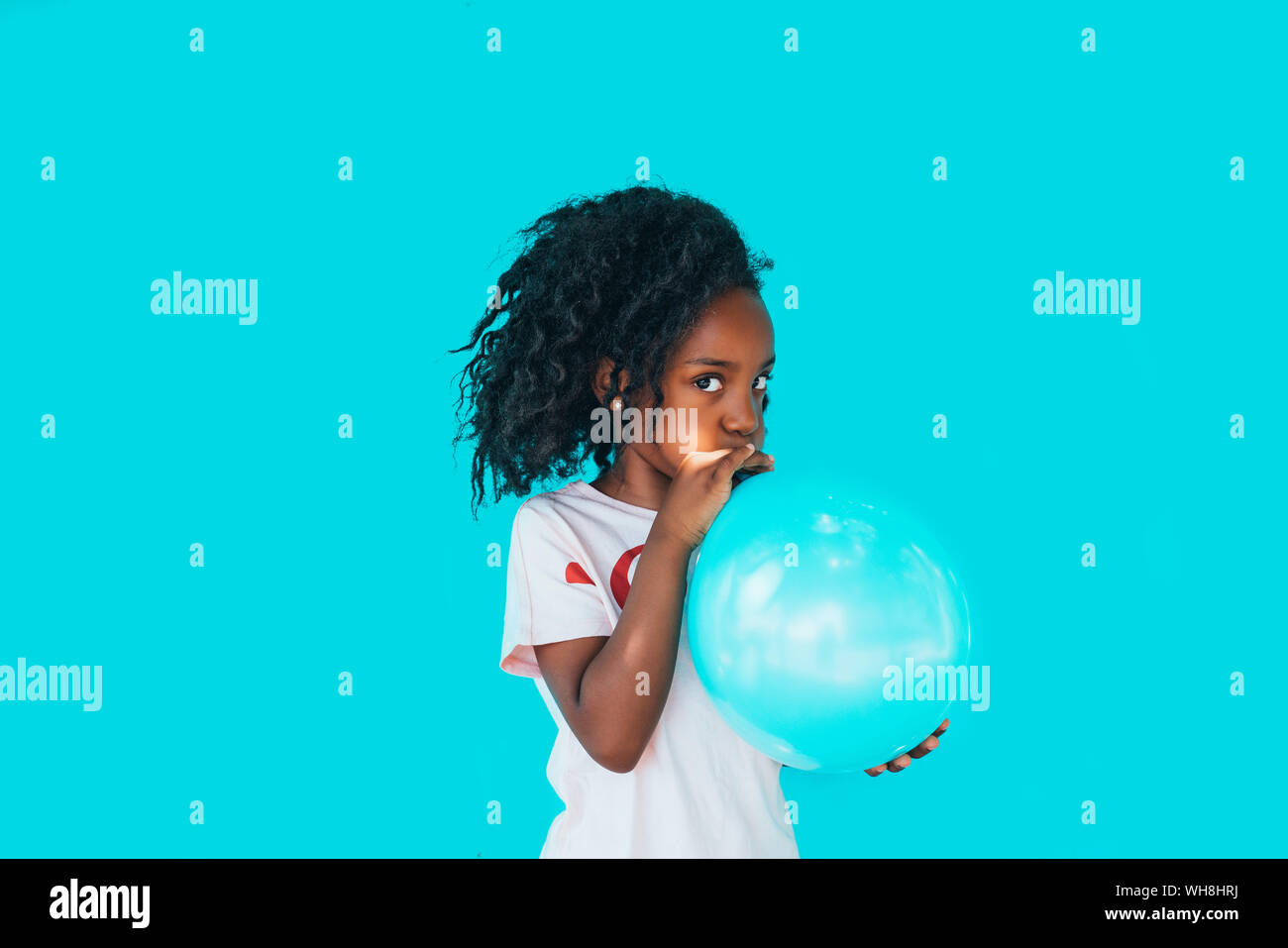 Petite fille devant un mur bleu, balloon Banque D'Images