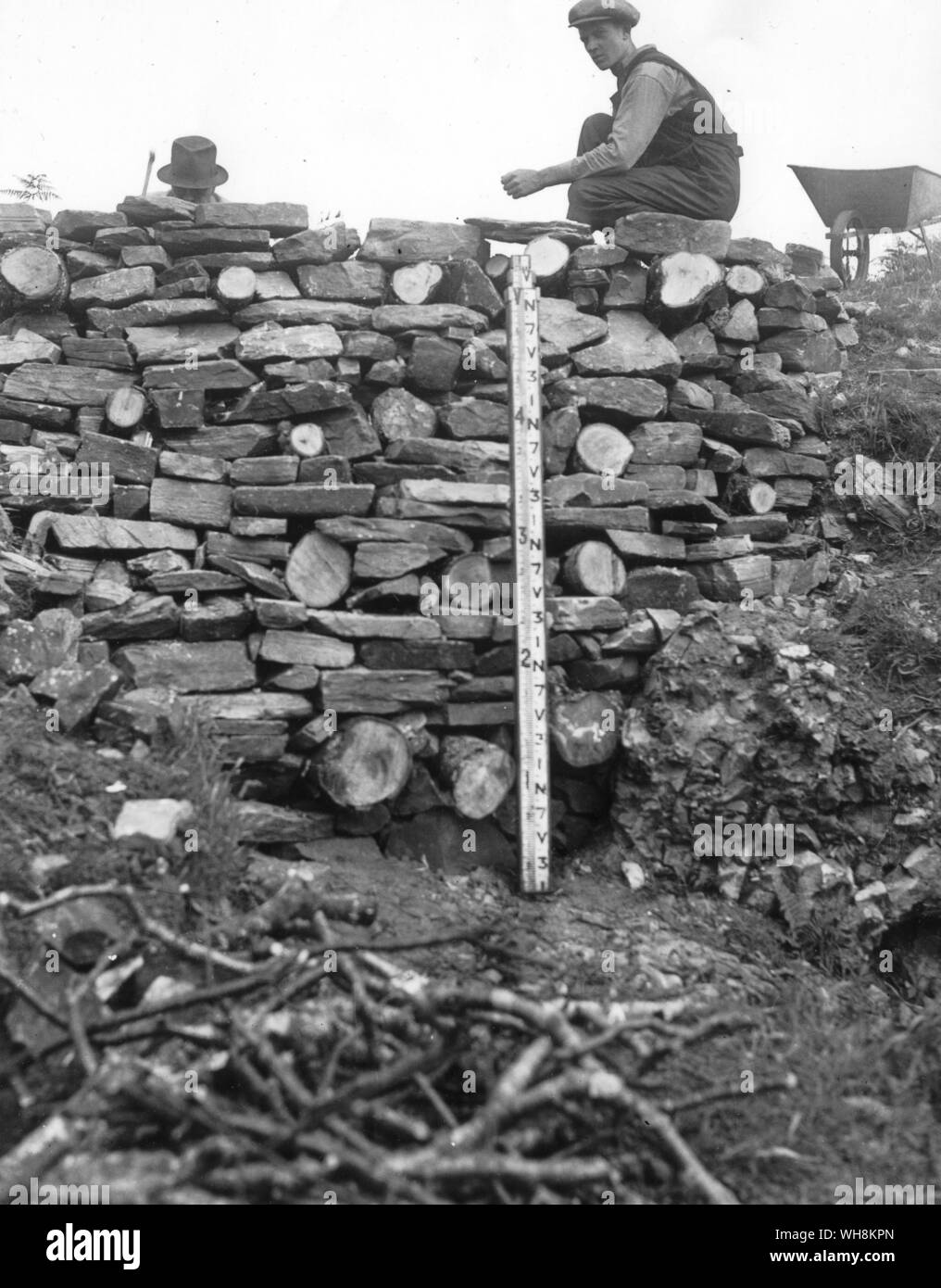 Gordon Childe (à peine visible) et son assistant sur un mur de feu à Rahoy en 1937 pour prouver sa théorie de vitrification Banque D'Images