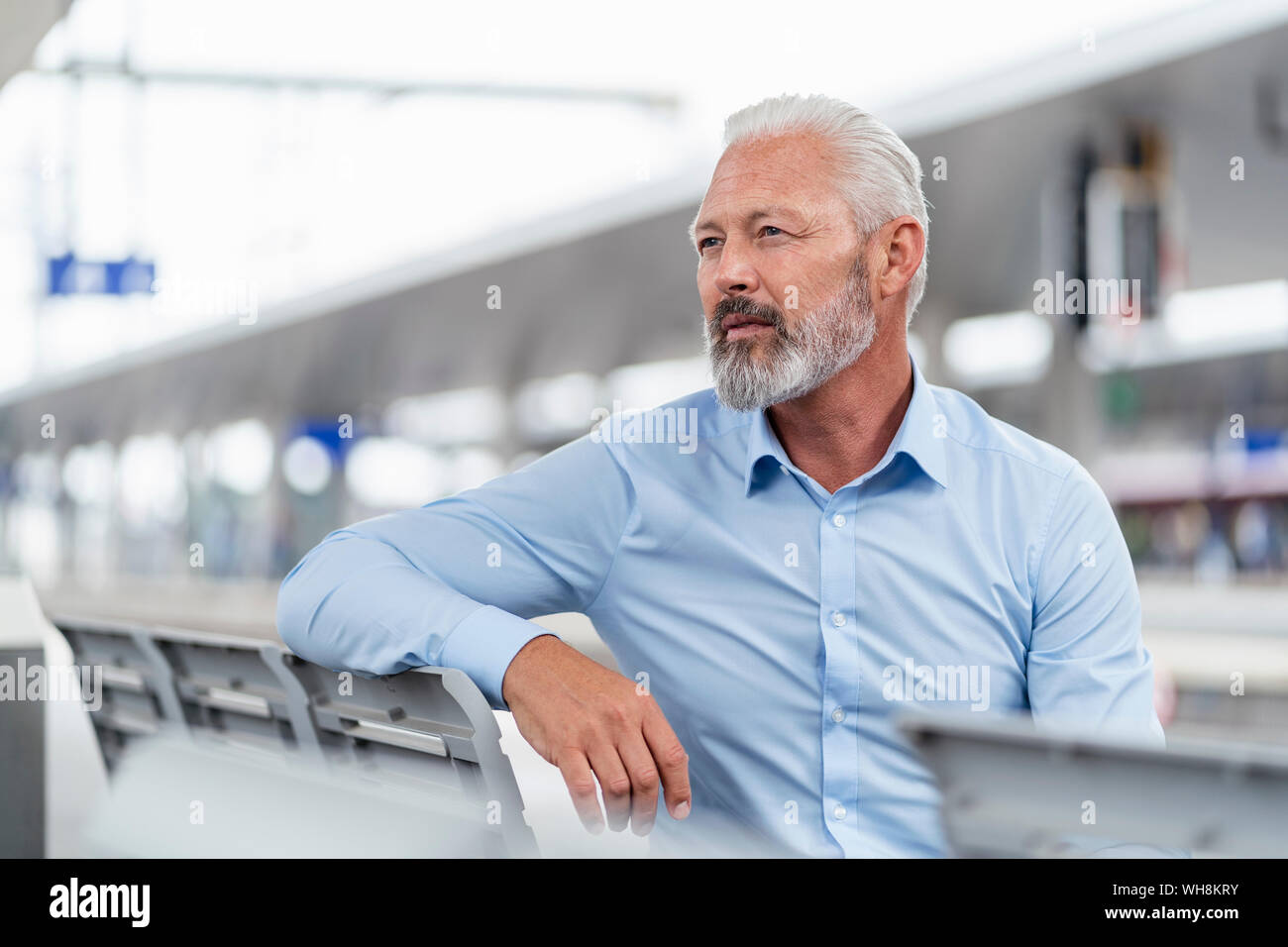 Mature businessman sitting at le quai de la gare à la recherche autour de Banque D'Images
