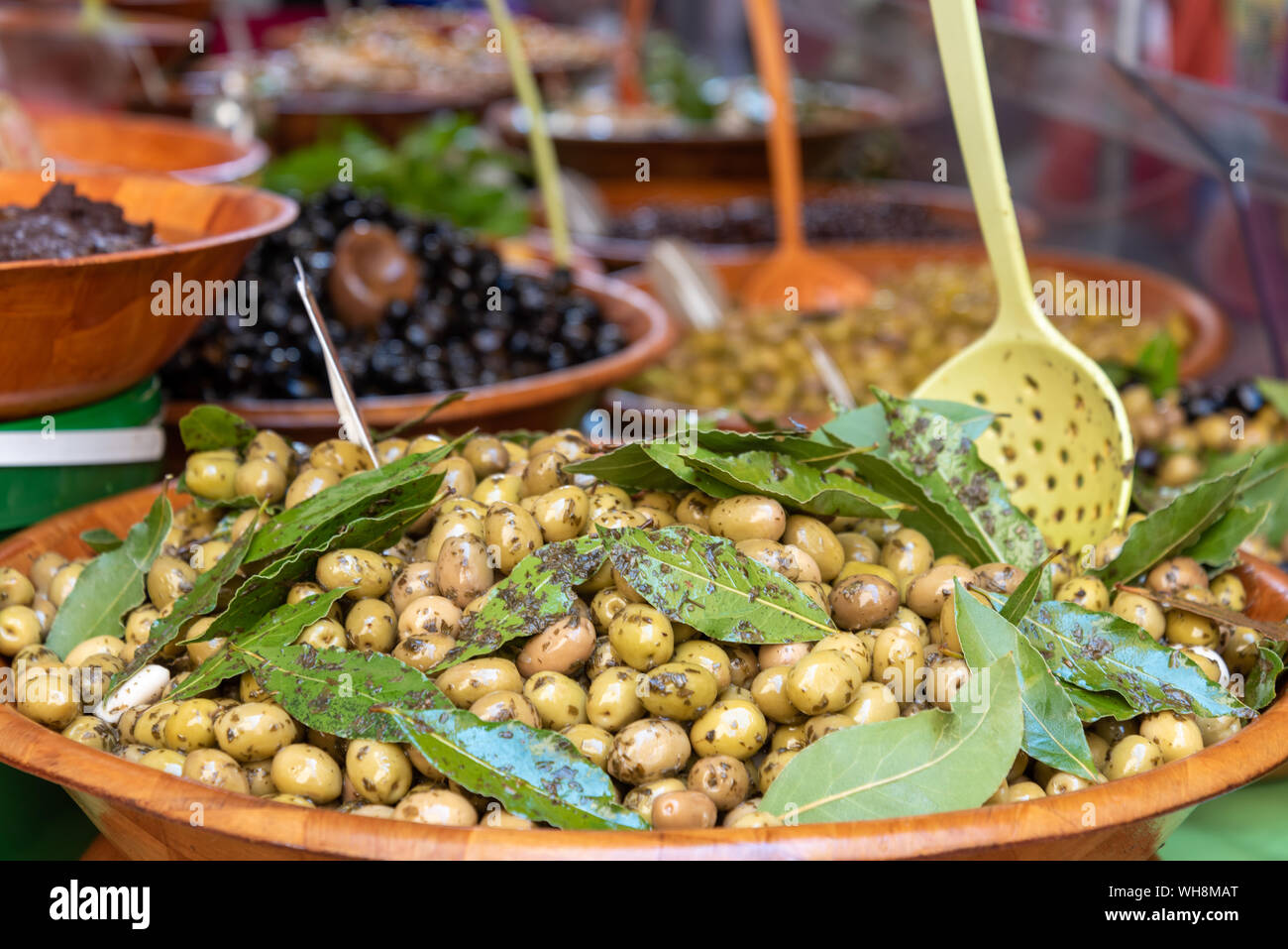 Gros plan des olives fraîches dans un bol avec des cuillères en bois à vendre Dans un marché de rue en Provence France Banque D'Images
