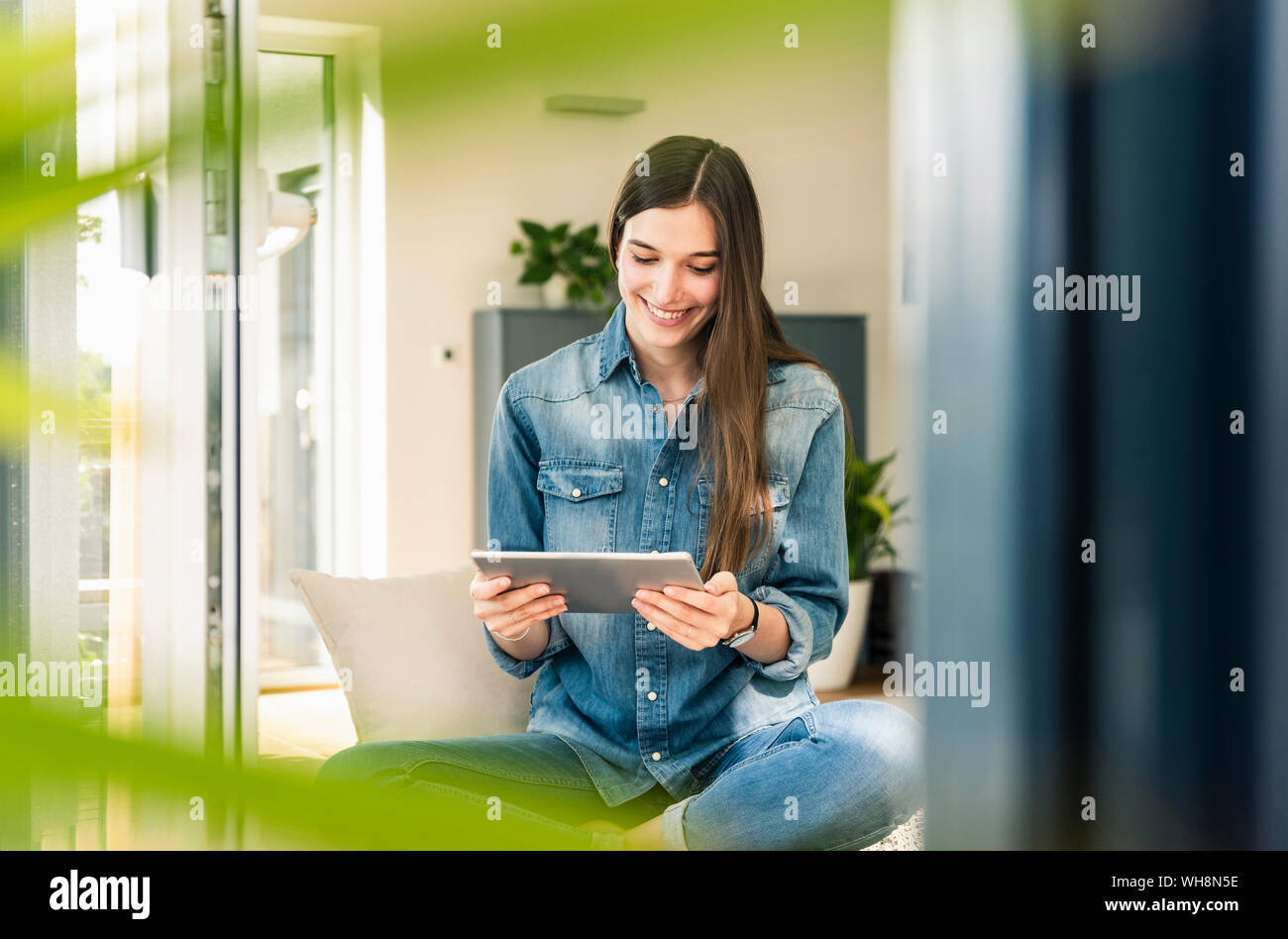 Smiling young woman using tablet Banque D'Images