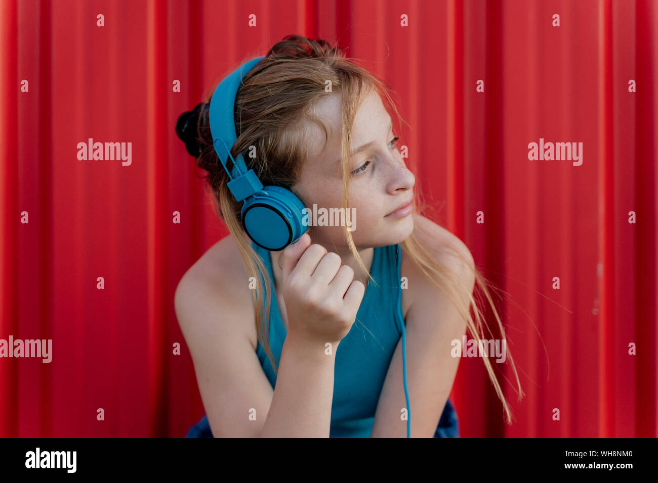 Fille avec un casque en face de red wall Banque D'Images