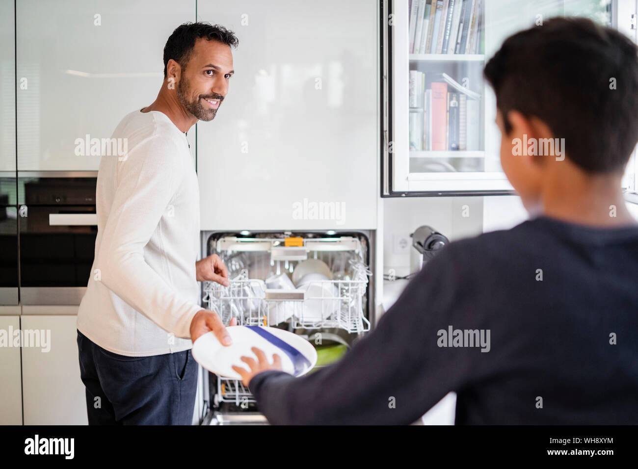 Père et fils dans la cuisine lave-vaisselle ensemble de compensation Banque D'Images