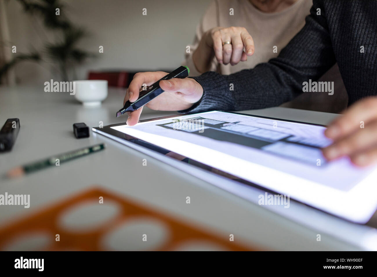 Close-up de l'homme à l'aide de tablette avec plan d'architecture Banque D'Images