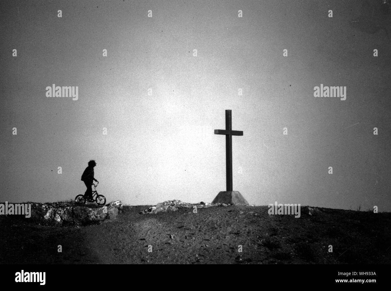 Enfant autochtone sur le vélo à côté de croix à Hermannsburg Mission historique une entreprise luthérienne Banque D'Images
