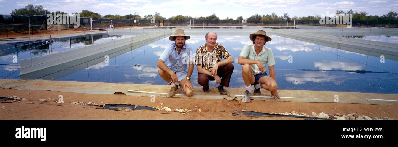Bob Collins et partenaires avec étang solaire derrière eux Banque D'Images