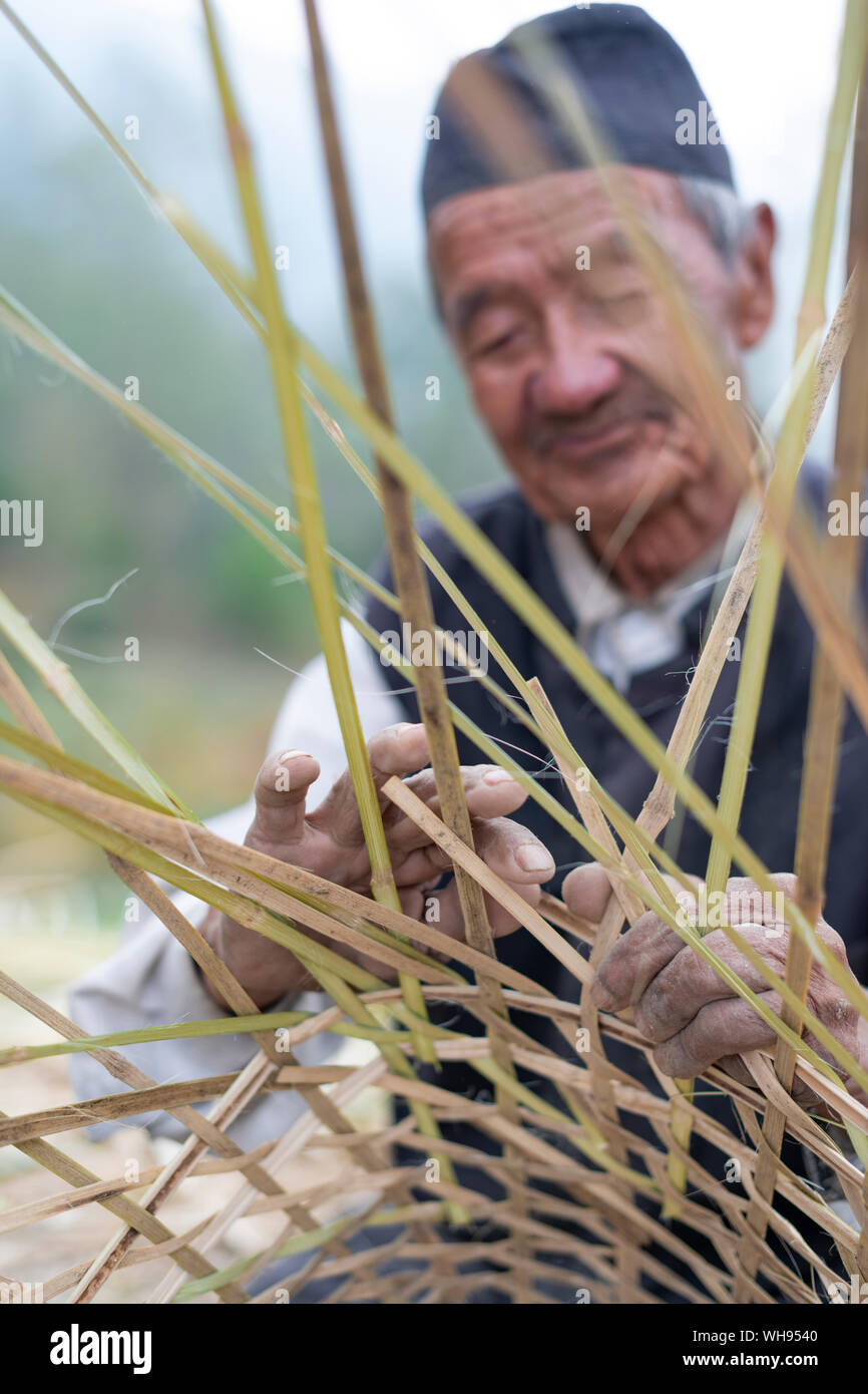 Un vieil homme fait un Népalais panier traditionnel par tissage bambou, Vallée de Kathmandou, Népal, Asie Banque D'Images