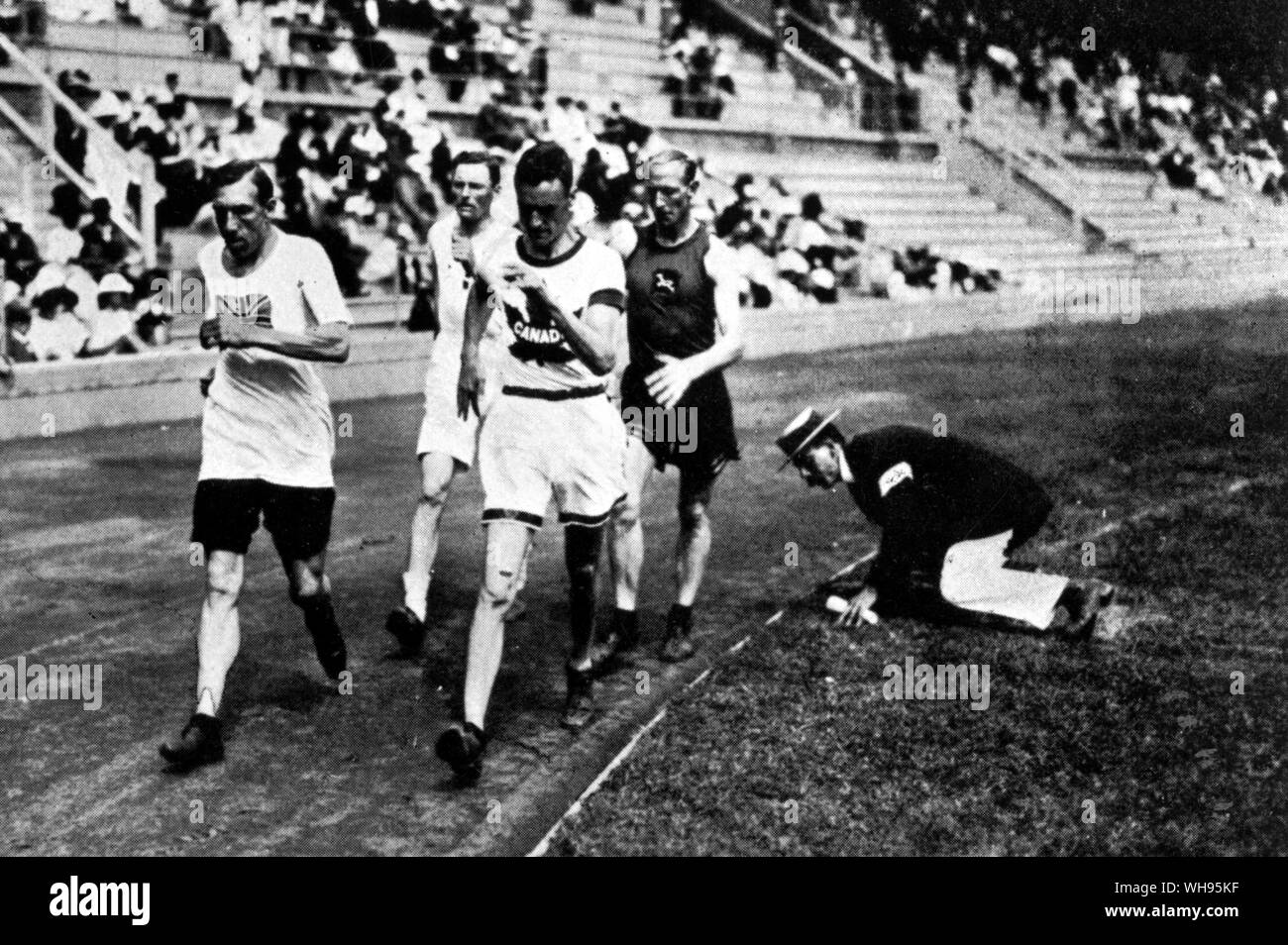 Concurrents sur le 10 000 mètres à pied d'être suivi de près pour s'assurer de ne pas rompre le contact avec le terrain de jeux Olympiques de Stockholm 1912 Banque D'Images