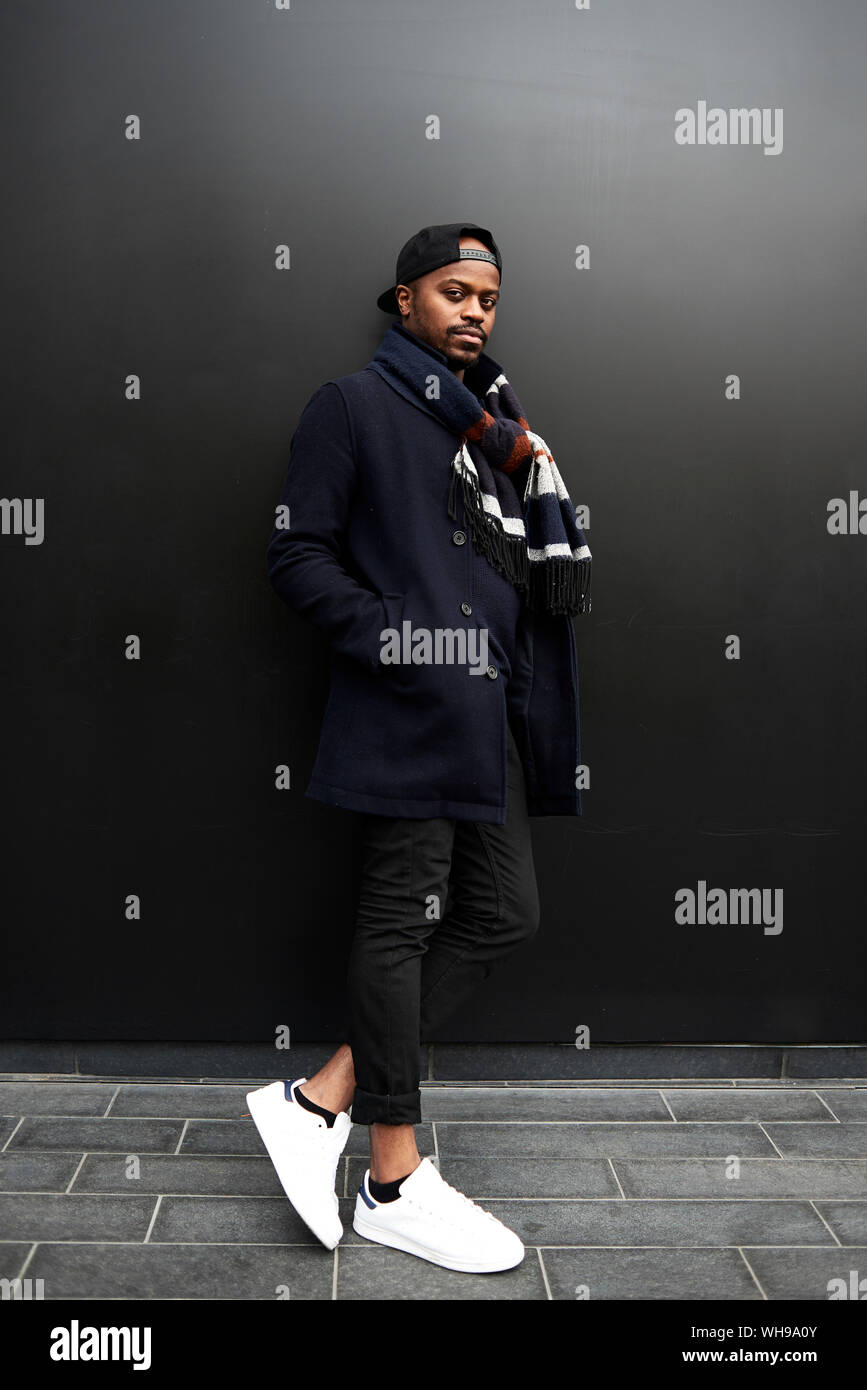 Portrait d'homme élégant, debout devant un fond sombre Banque D'Images