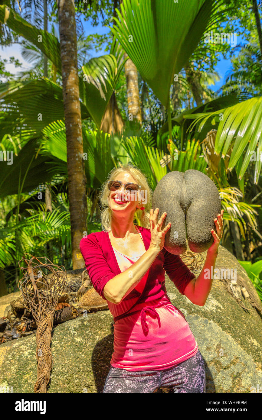 Les touristes détenteurs Coco de Mer à fond Ferdinand réserve naturelle, près de Anse Marie-Louise, Praslin, Seychelles, océan Indien, Afrique Banque D'Images