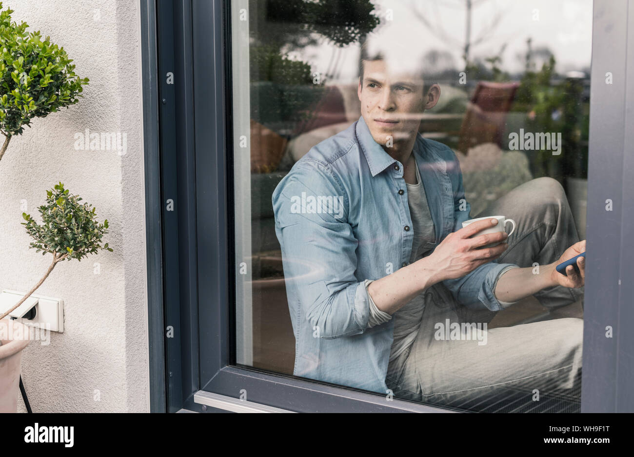 Homme assis st la fenêtre, de boire du café Banque D'Images