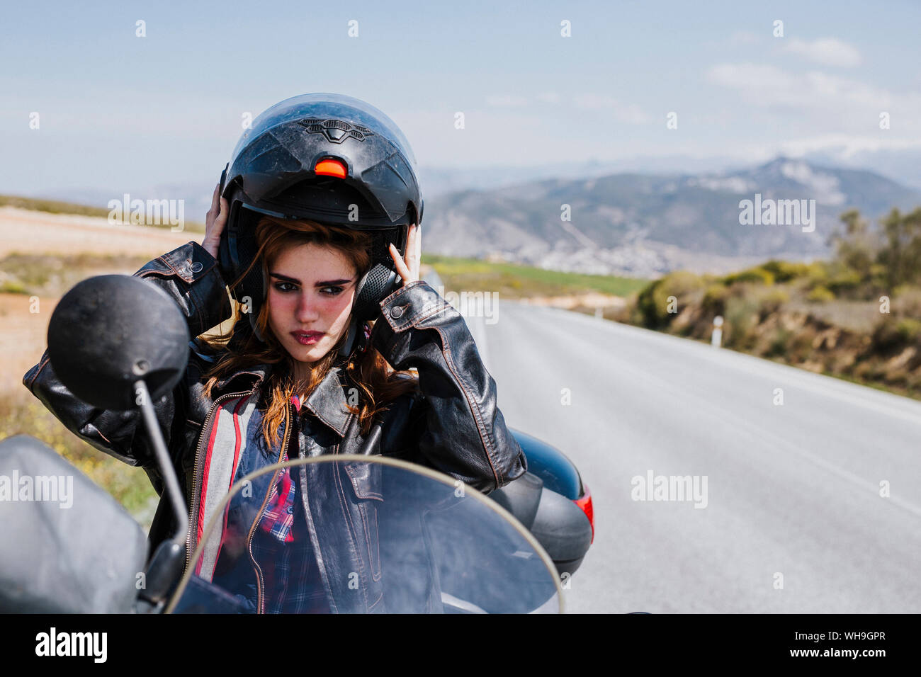 Portrait d'un motocycliste mise sur casque, Andalousie, Espagne Banque D'Images