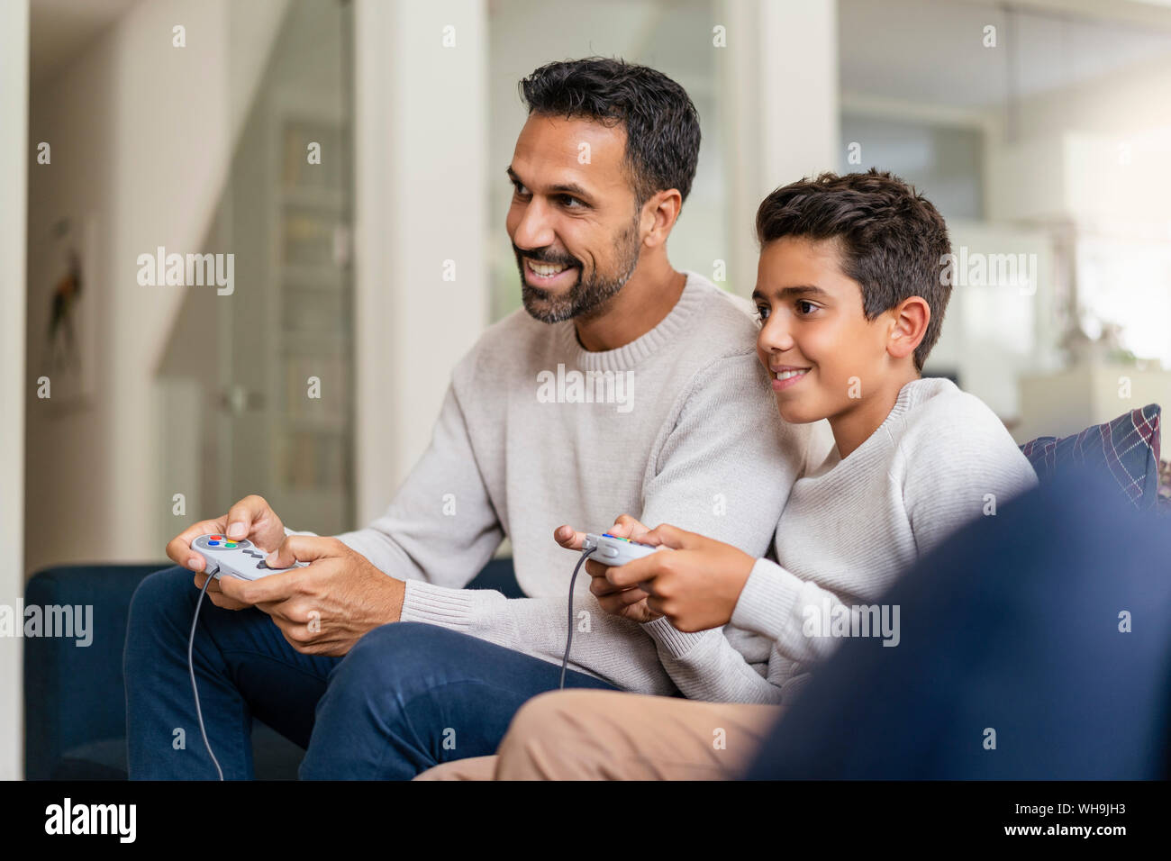 Happy father and son playing video game sur la table dans la salle de séjour Banque D'Images Happy father and son playing video game sur la table dans la salle de séjour Banque D'Images