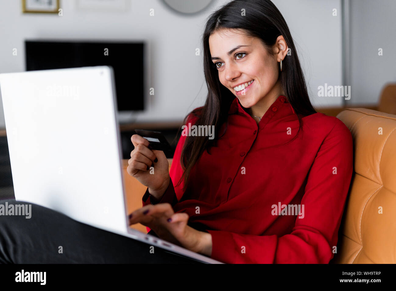 Happy young woman at home achats en ligne Banque D'Images