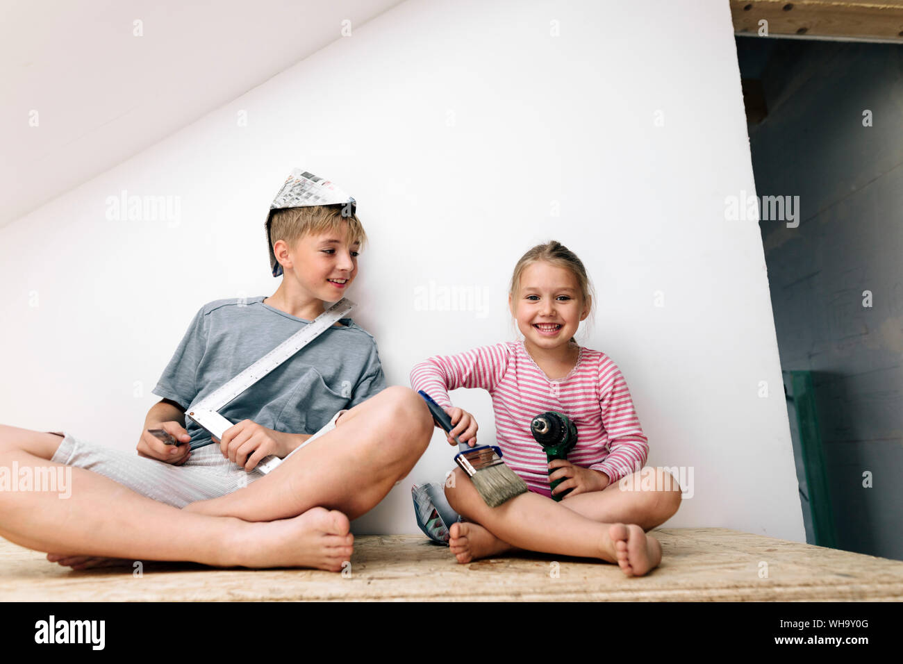 Heureux frère et sœur dans une maison à rénover Banque D'Images