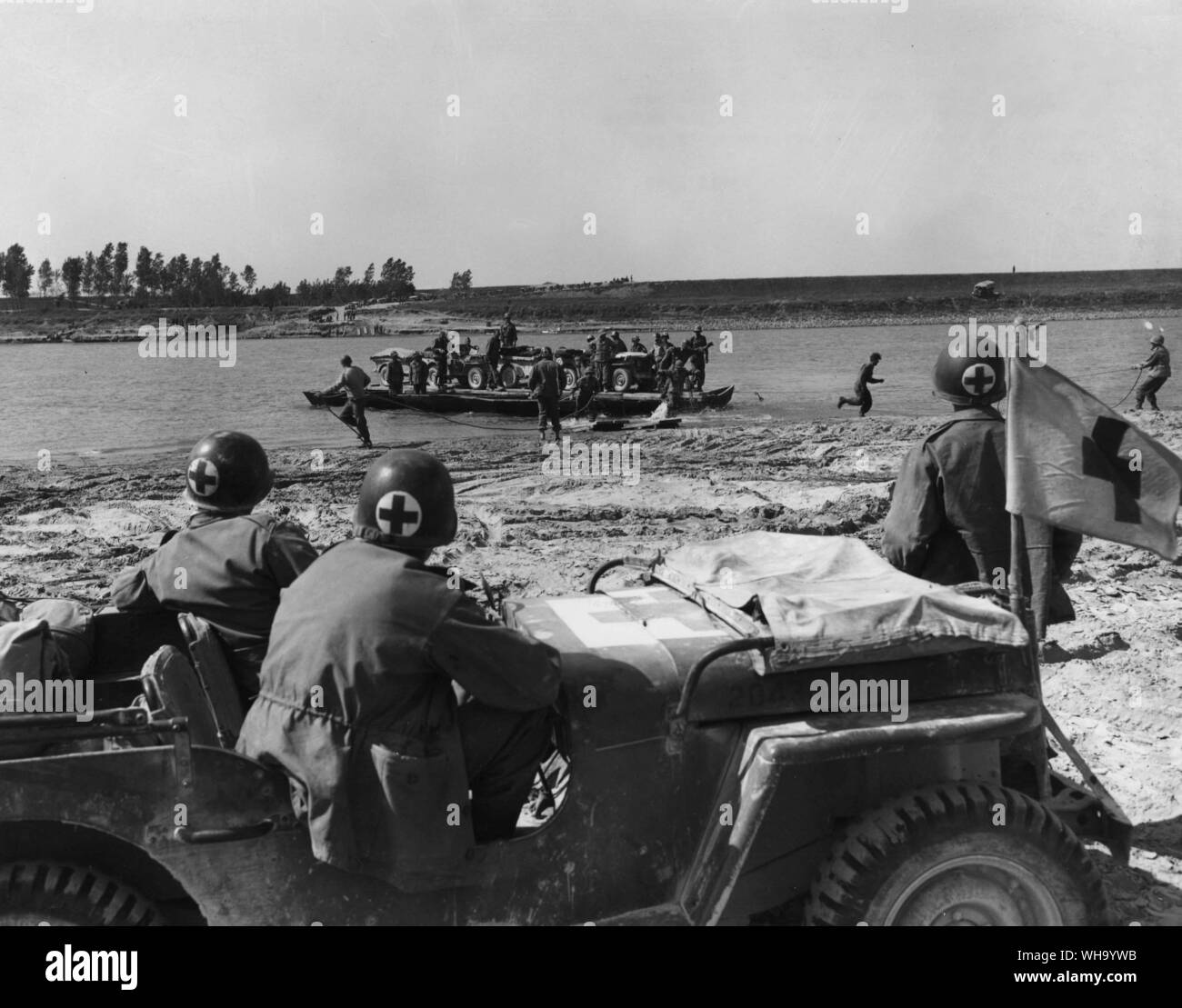 WW2 : la région de la rivière Po, Italie. Approche du côté nord de la rivière Po avec les véhicules et le personnel de la péniche de débarquement sont traitées rapidement par les hommes sur la rive et les médecins sont sur place en cas d'accidents. 5e armée. Avril 1945. Banque D'Images