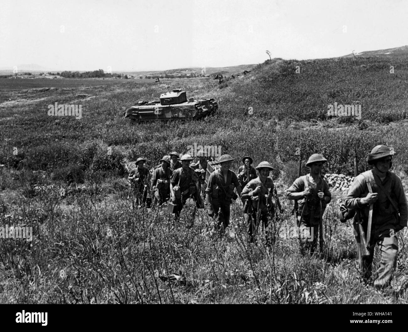 WW2 : l'Afrique du Nord. Première attaque de l'armée sur la Colline Longston, avril 1943. Aller de l'infanterie jusqu'à l'attaque. Dans l'arrière-plan est l'un des chars Churchill qui ont pris part à cette opération. Banque D'Images