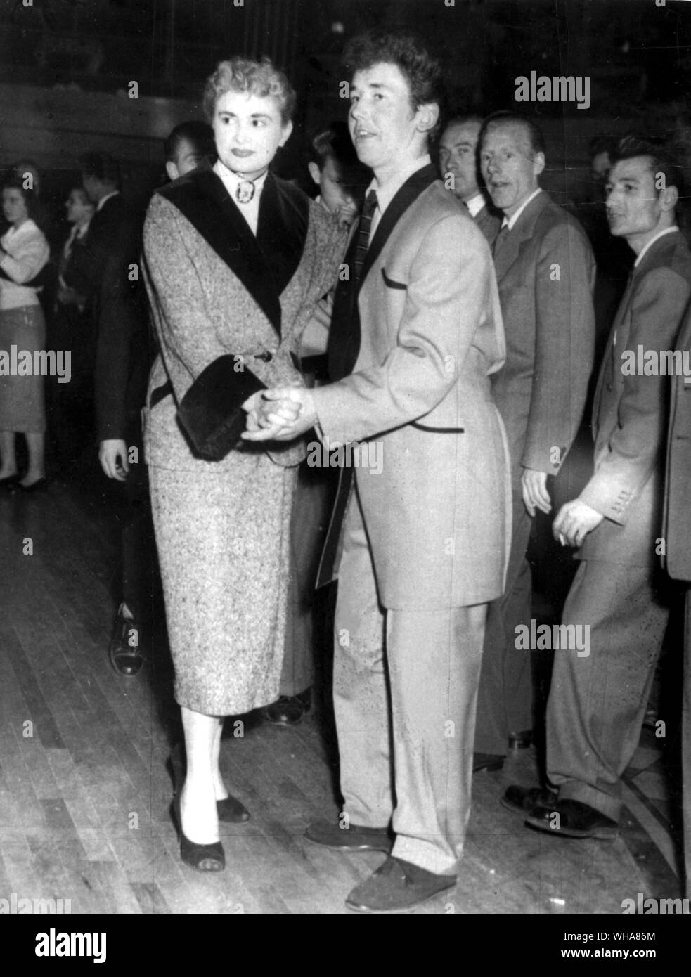 Teddy Girl et Teddy Boy. Teddy girl Shirley Phillips, 18 ans, de Stoke Newington, Londres, dispose d'un Tweed Donegal deux pièces avec un large col de velours noir et de larges poignets assortis. Bob Corbett 17 partenaire de Liverpool porte un costume gris argent noir noir avec revers et la tuyauterie et brown suede chaussures. Une version avancée d'un légèrement Teddy orthodoxe tenue. Juin 1954 Banque D'Images